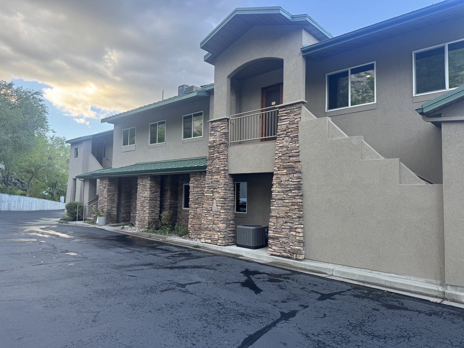 Two-story commercial building with stone columns and a full set of freshly rescreened windows.