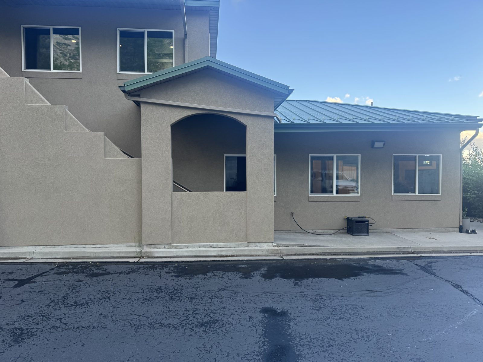 Side elevation of a commercial building showing a row of rescreened windows and a covered stair entry.